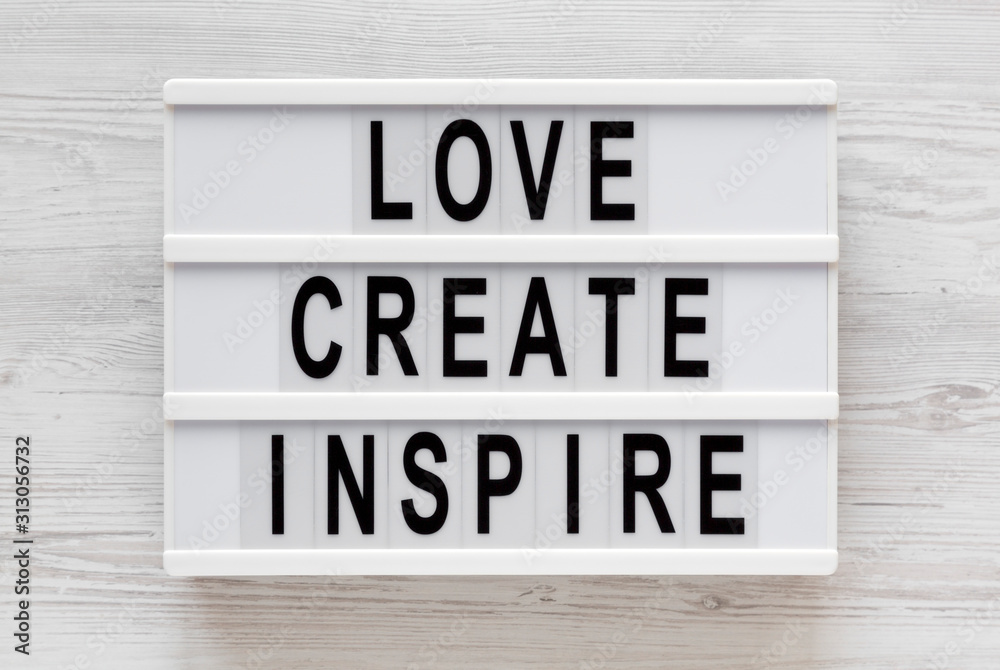 'Love create inspire' words on a lightbox on a white wooden background, top view. Overhead, from above, flat lay. 'Love create inspire' words on a lightbox on a white wooden background, top view. Overhead, from above, flat lay.