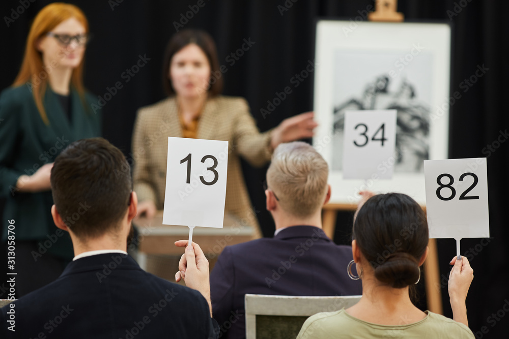 Rear view of people are going to buy modern art while sitting at auction - obrazy, fototapety, plakaty 