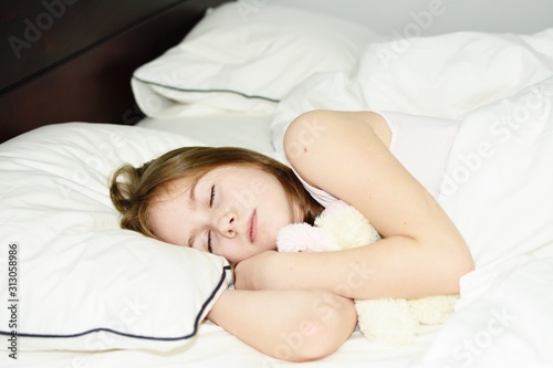 White Caucasian young girl (child, kid) sleep in bed. Lifestyle concept.