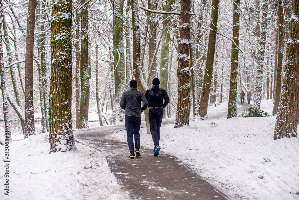 Two men go for a run in a winter Park