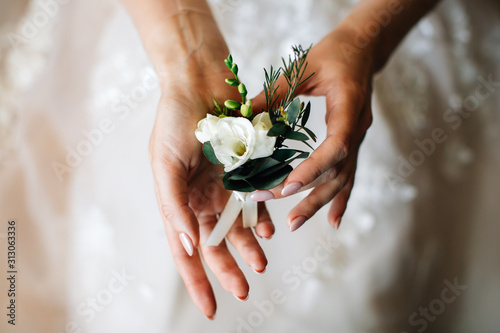 Vászonkép Close-up of the bride's hands holds a buttonhole