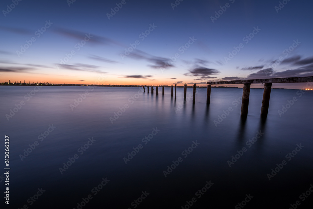 Jetty leading into the water at sunset 