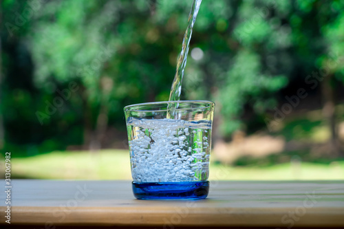 Pouring pure water in to the glass make spread of water crystal bubble with background nature