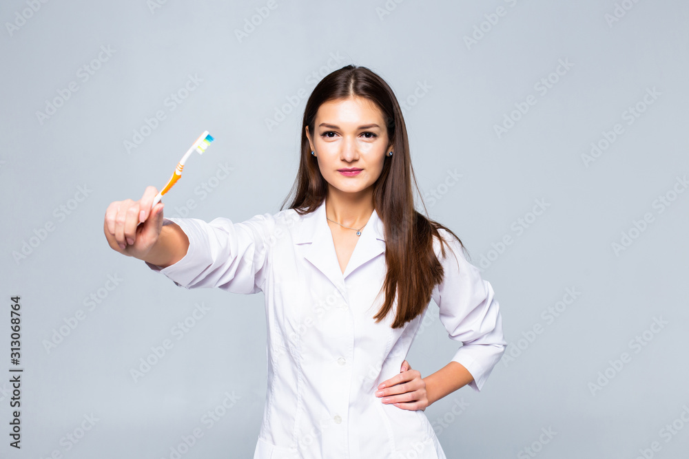 Smiling woman medic with braces with great teeth holding tooth-brush, isolated on white background Smiling woman medic with braces with great teeth holding tooth-brush, isolated on white background