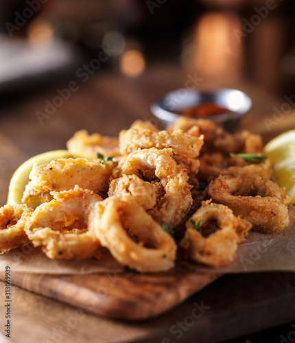 crispy fried calamari rings with marinara dipping sauce and lemon