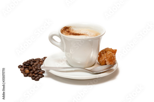 Cup of coffee with milk and cinnamon, a sweet to accompany it