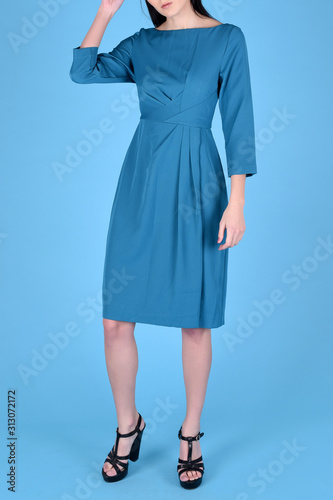 Woman brunette hair wearing blue color fashion clothes, business style dress for office. Model wear stylish trend clothing classic blue 2020 cotton casual style. Studio shot on light blue background