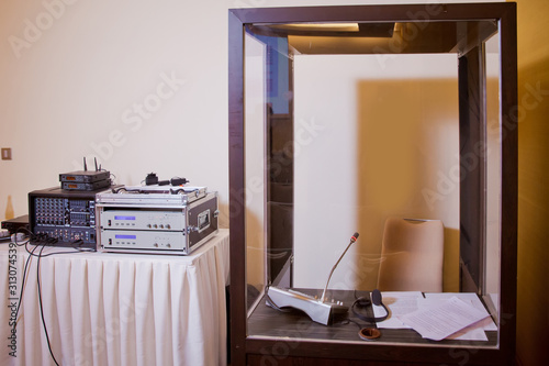 Soft focus of wireless Conference microphones and notebook in a meeting room. translators cubicle . interpreting - Microphone and switchboard in an simultaneous interpreter booth .