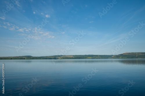 idyllic peaceful calm nature scenic landscape of main land horizon background coast line and ocean bay peaceful water surface foreground in summer time morning, copy space for text