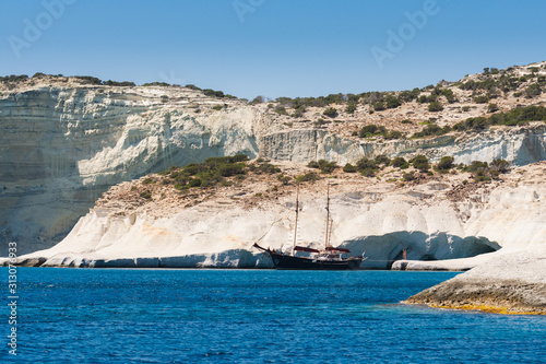 Aegean Crustal Sea Water and Rock Formations and Ship in Milos Island Greece