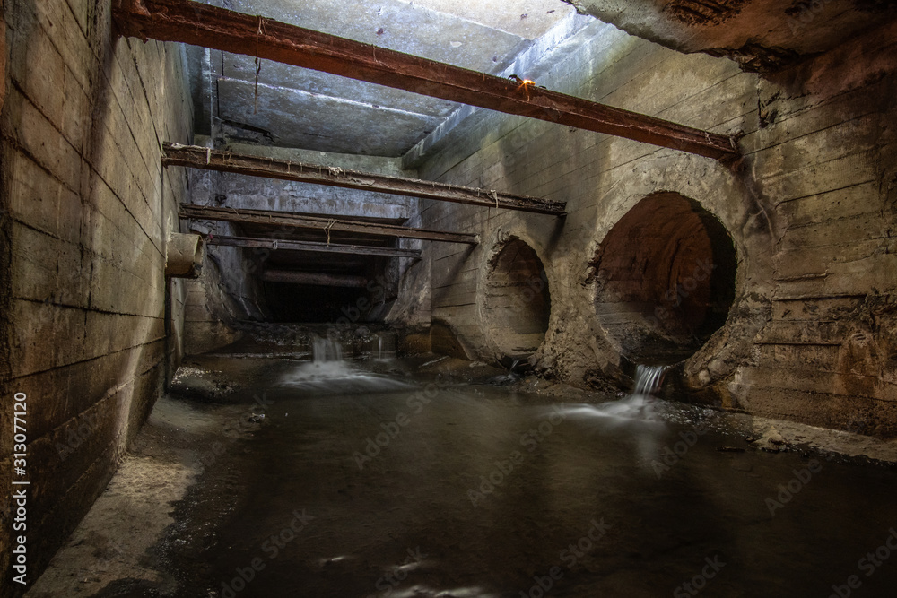 Big square rainwater drainage tunnel, with drain pipes. Stock Photo