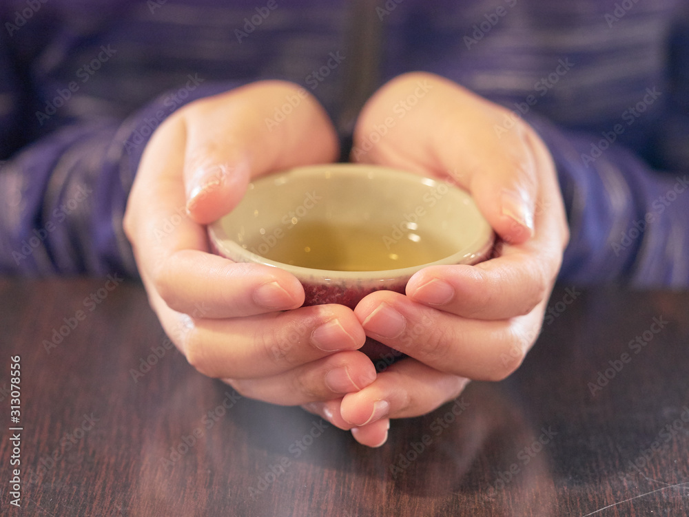 Holding a traditional cup of tea with hands Holding a traditional cup of tea with hands
