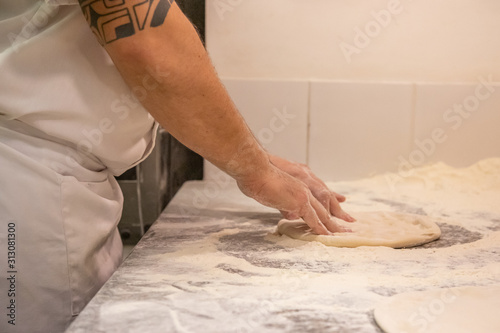 pizza maker takes dough ball to make pizza
