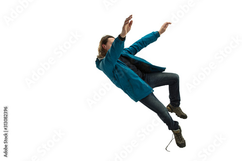 A second before falling. Caucasian young man falling down in moment with bright emotions and facial expression. Male model in casual clothes on white. Shocked, scared, screaming. Copyspace for ad.