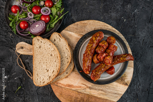 Fototapeta Naklejka Na Ścianę i Meble -  German, traditional baked sausage with curry sauce on a dark background