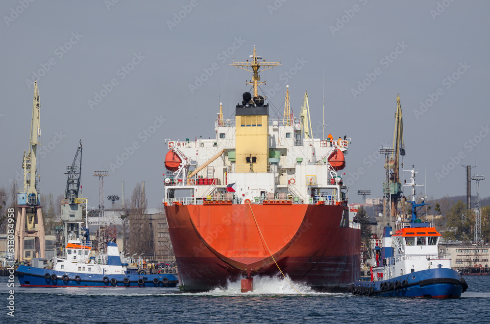 MARITIME TRANSPORT - A Tugboat and freighter maneuver in seaport