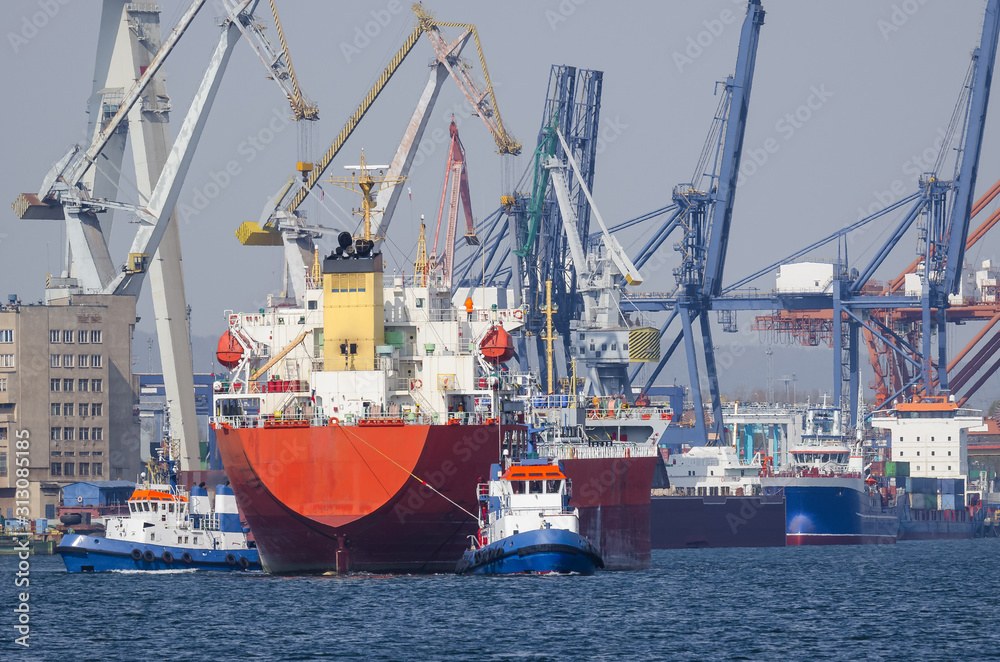 MARITIME TRANSPORT - A Tugboat and freighter maneuver in seaport MARITIME TRANSPORT - A Tugboat and freighter maneuver in seaport