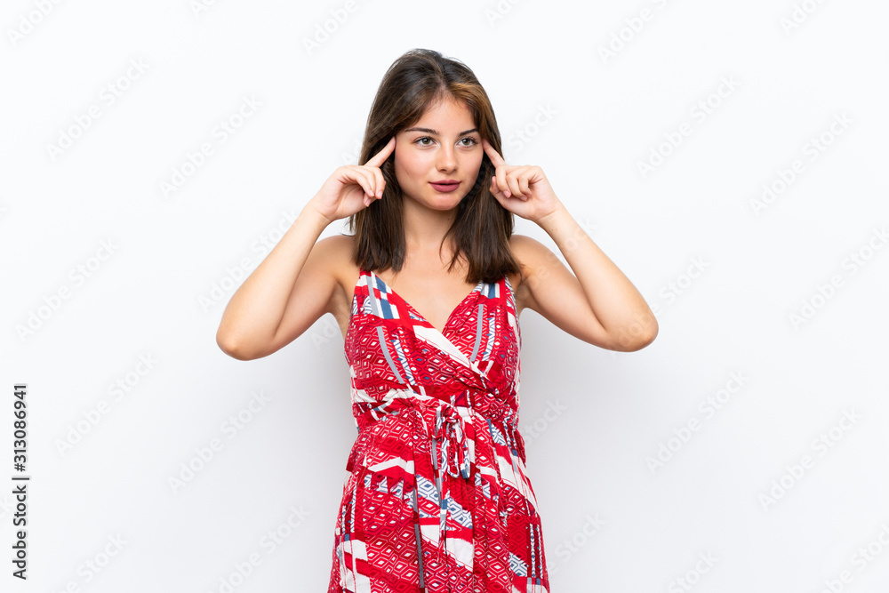 Caucasian girl in red dress over isolated white wall having doubts and thinking Caucasian girl in red dress over isolated white wall having doubts and thinking