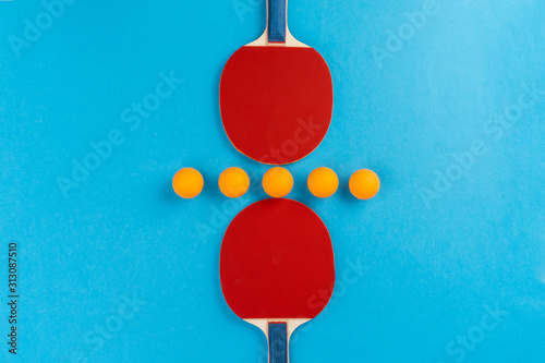 Ping pong racket and ball on blue background