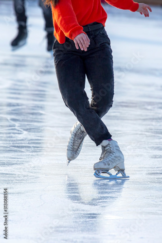 feet on the skates of a person rolling on the ice rink. Hobbies and sports. Vacations and winter activities.