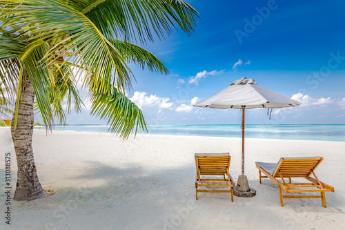 Beach chairs with umbrella on paradise beach island with ocean view. Luxury summer travel destination and vacation or holiday concept design. Tropical beach landscape