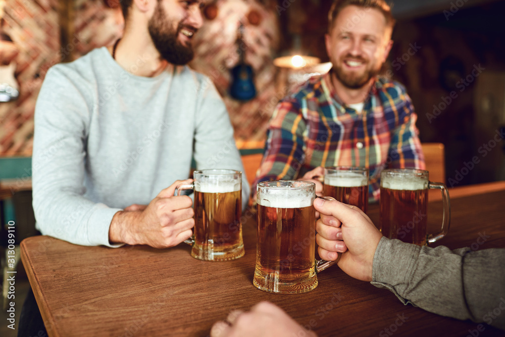 Friends people drink beer, talk in a pub.