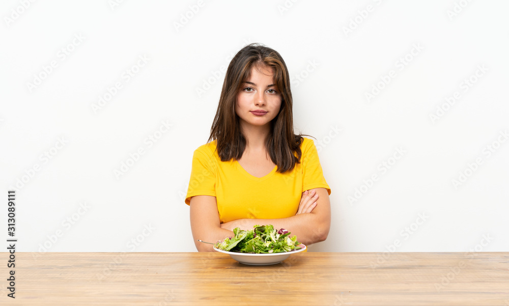 Caucasian girl with salad keeping arms crossed Caucasian girl with salad keeping arms crossed