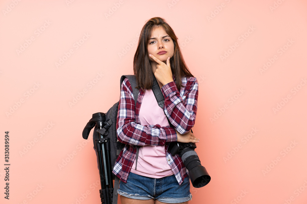 Young photographer girl over isolated pink background laughing Young photographer girl over isolated pink background laughing