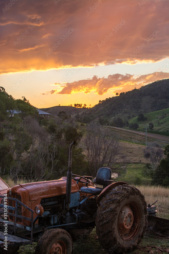 Tractor on farm with sunset in background Tractor on farm with sunset in background