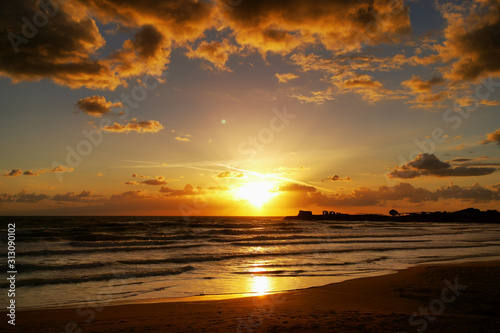 Goldener Sonnenuntergang über dem Mittelmeer am Strand von Sizilien