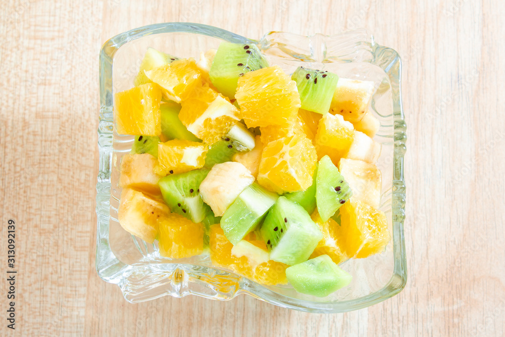 healthy breakfast salad of orange banana and kiwi in a glass dish on a wooden background fitness food. copy space healthy breakfast salad of orange banana and kiwi in a glass dish on a wooden background fitness food. copy space
