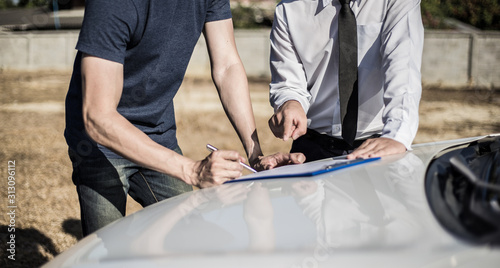 Customers and car insurance agents have entered into agreements and signed documents to claim compensation after a car crash, Insurance concept.