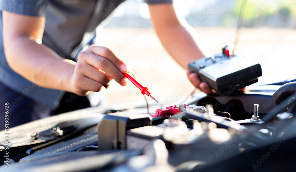 Auto repair technician has inspected the condition of the engine using ammeter, Car repair service concept. Auto repair technician has inspected the condition of the engine using ammeter, Car repair service concept.