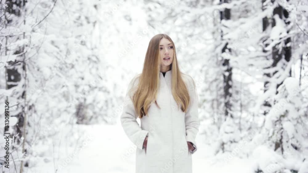 Beautiful woman in winter forest. Young elegant lady in trendy white coat. Fashion winter lookbook. Winter snow-covered forest Beautiful woman in winter forest. Young elegant lady in trendy white coat. Fashion winter lookbook. Winter snow-covered forest