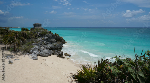 Mayan ruins tower over the coast of Caribbean sea in Tulum. It is the site of a pre-Columbian Mayan walled city serving as a major port for Coba city in Mexico. 