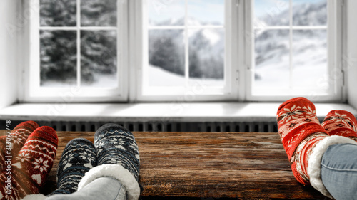 White wooden winter window and woman legs with woolen socks. 
