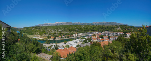 View of the city of Obrovac, the Zrmania river. On the right are the ruins of an old castle. Panorama