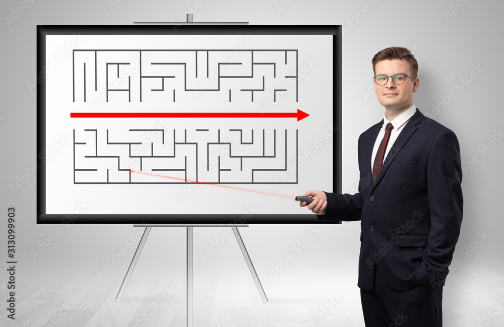Handsome businessman with laser pointer presenting potential exit from a labyrinth Handsome businessman with laser pointer presenting potential exit from a labyrinth