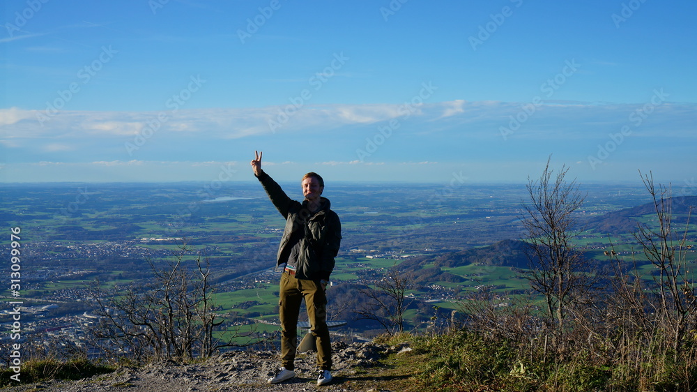 Tourist at the top Untersberg mountain and background with aerial panorama of Salzburg in Austria.