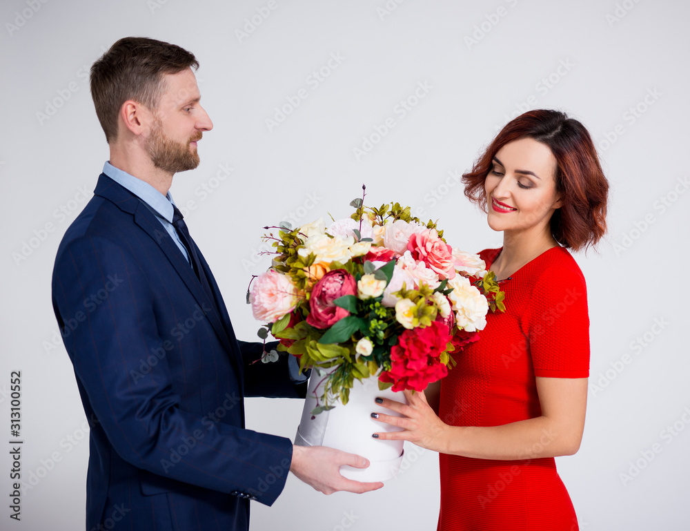 Valentine's day or birthday surprise concept - handsome man surprising his girlfriend with flowers over white Valentine's day or birthday surprise concept - handsome man surprising his girlfriend with flowers over white