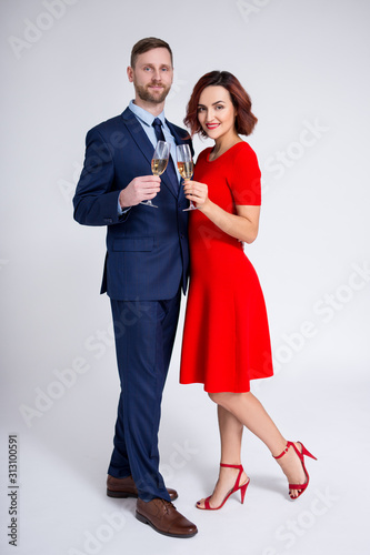 valentine's day, christmas and new year concept - full length portrait of beautiful couple posing with glasses of champagne over white