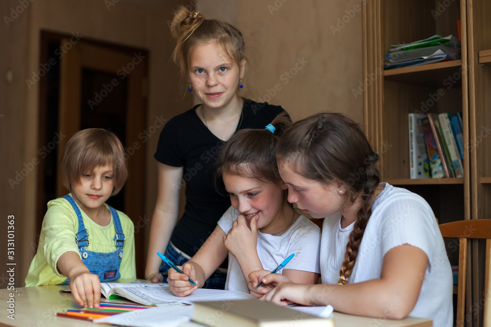 sisters are learning lessons at the table. sisters are learning lessons at the table.