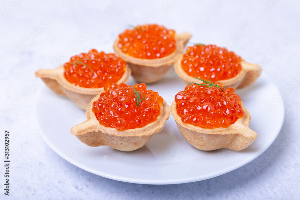 Red caviar (salmon caviar) in tartlets. Selective focus, close-up.