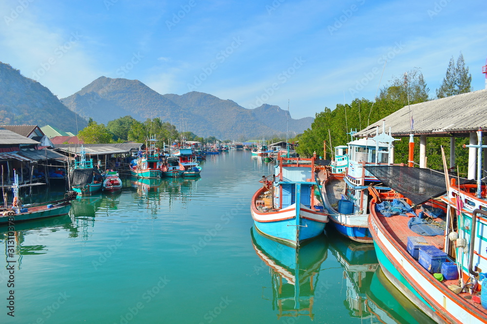 Colourful boats on river. The picturesque river landscape. Pier with beautiful wooden boats. River in mountains in the tropics.
