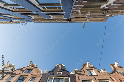Photography Dutch houses in narrow streets of Amsterdam viewed from below