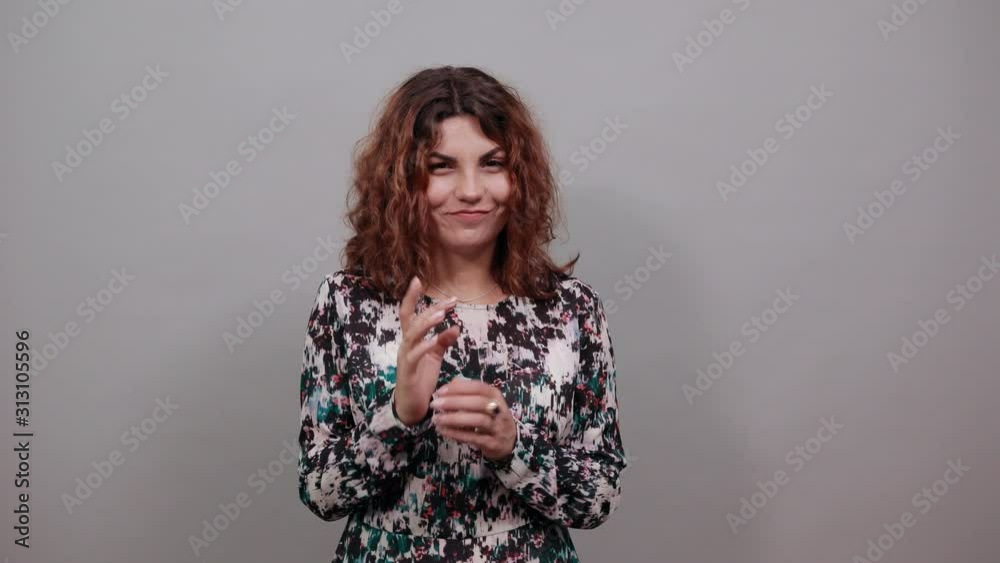 Unhappy conceived charming young lady over isolated gray background in fashion shirt keeping fingers together, thinking about something, having nice ring. People emotions. Lifestyle concept Unhappy conceived charming young lady over isolated gray background in fashion shirt keeping fingers together, thinking about something, having nice ring. People emotions. Lifestyle concept