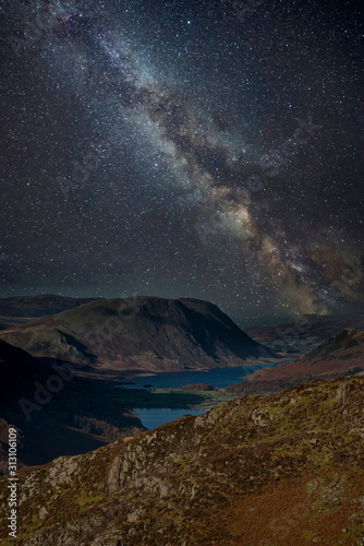 Stunning majestic digital composite landscape of Milky Way over Haystacks and High Stile in Lake District © veneratio