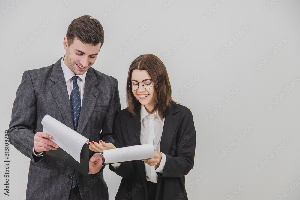 Successful businesspartners standing, holding clipboards, flipping over pages, looking through the documents, discussing important issues.