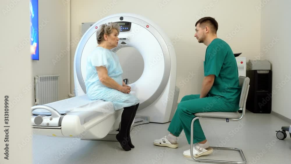 Procedure of computer tomography or magnetic resonance imaging. Elderly woman on medical examination. A doctor talking to a female patient. 4K Procedure of computer tomography or magnetic resonance imaging. Elderly woman on medical examination. A doctor talking to a female patient. 4K