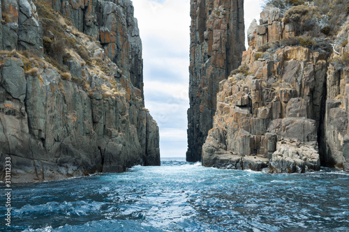 фотографія Water flowing through a rock formation, with seals on the cliff face